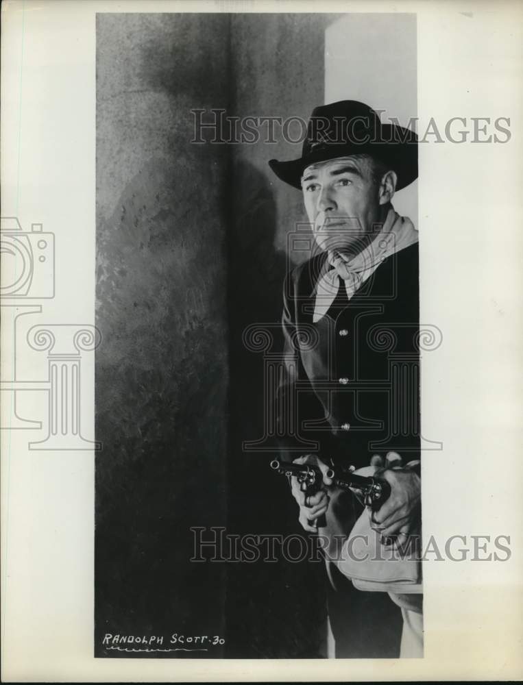 1954 Press Photo Randolph Scott holds his six-guns. - hcx52220- Historic Images