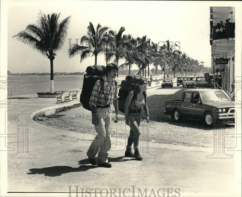 1983 Press Photo Backpacking couple with supplies strapped on their backs.- Historic Images