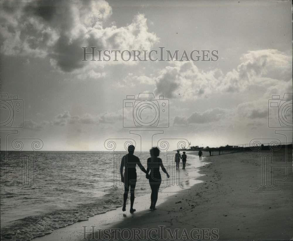 1965 Press Photo Bahamas' visitors walking the beach. - hpa00532