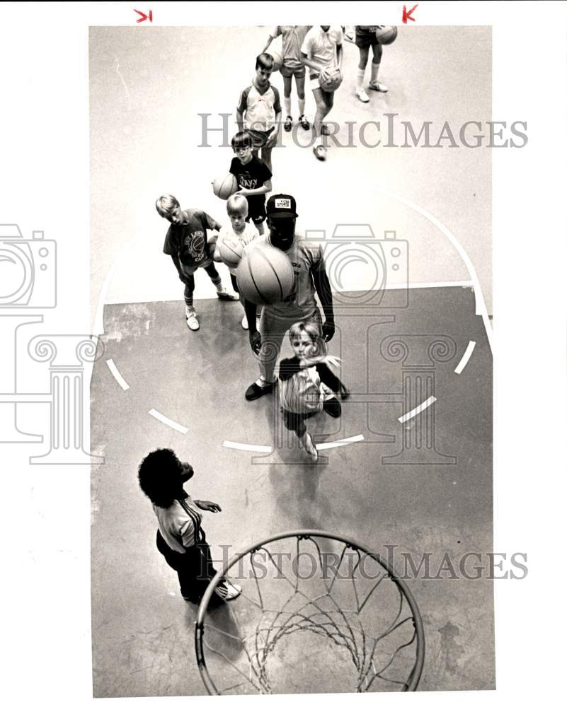 1983 Press Photo Mike Young offers basketball pointers to Chris Miller.- Historic Images