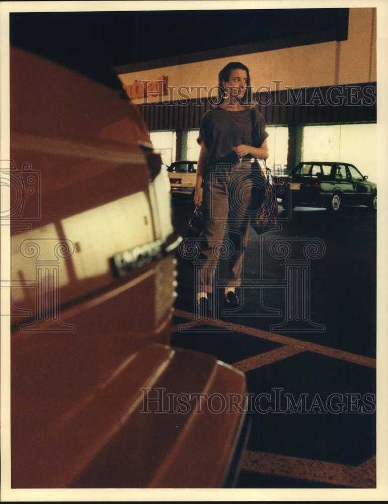 1991 Press Photo Woman Walking to Car in Parking Lot in Nighttime Crime Feature- Historic Images