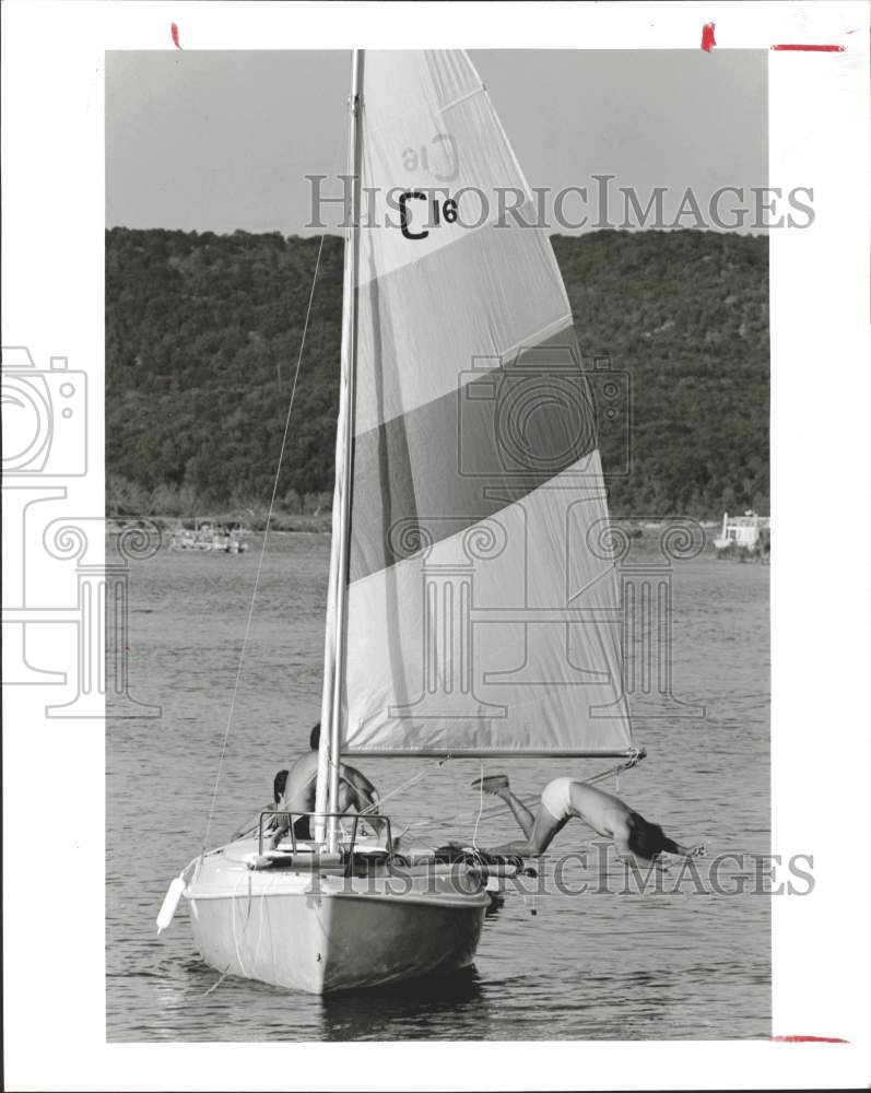 1983 Press Photo Man dives from boat into Lake Travis in Austin, Texas.- Historic Images