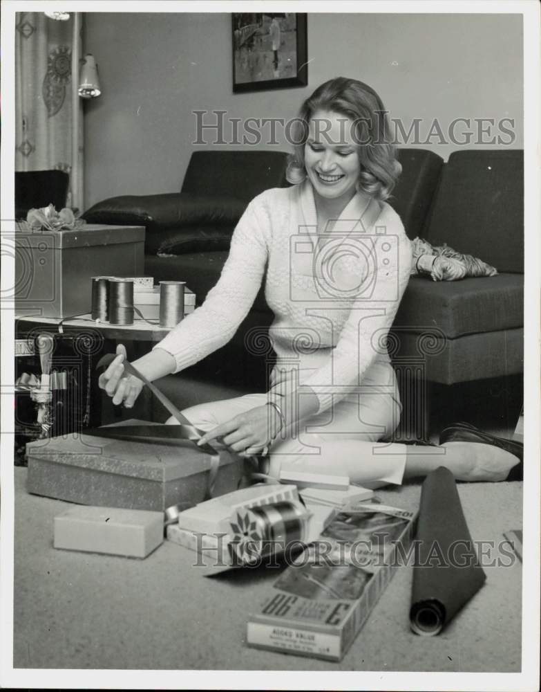 1962 Press Photo Marie Bittner, Sohio Petroleum secretary, wraps gifts.- Historic Images