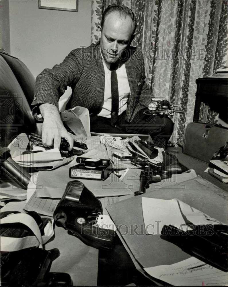 1969 Press Photo Judge Lee Duggan, Jr., inspects evidence of weapons.- Historic Images