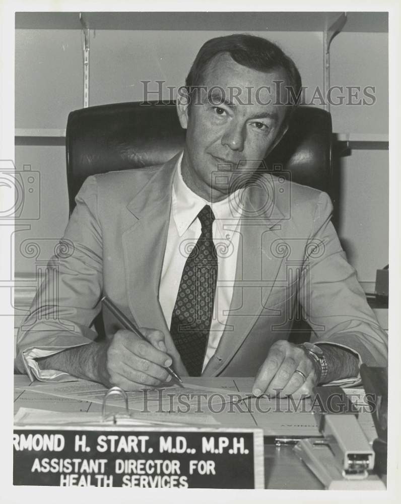 Press Photo Dr. Armond Start, TDC Medical Director works at his desk.- Historic Images