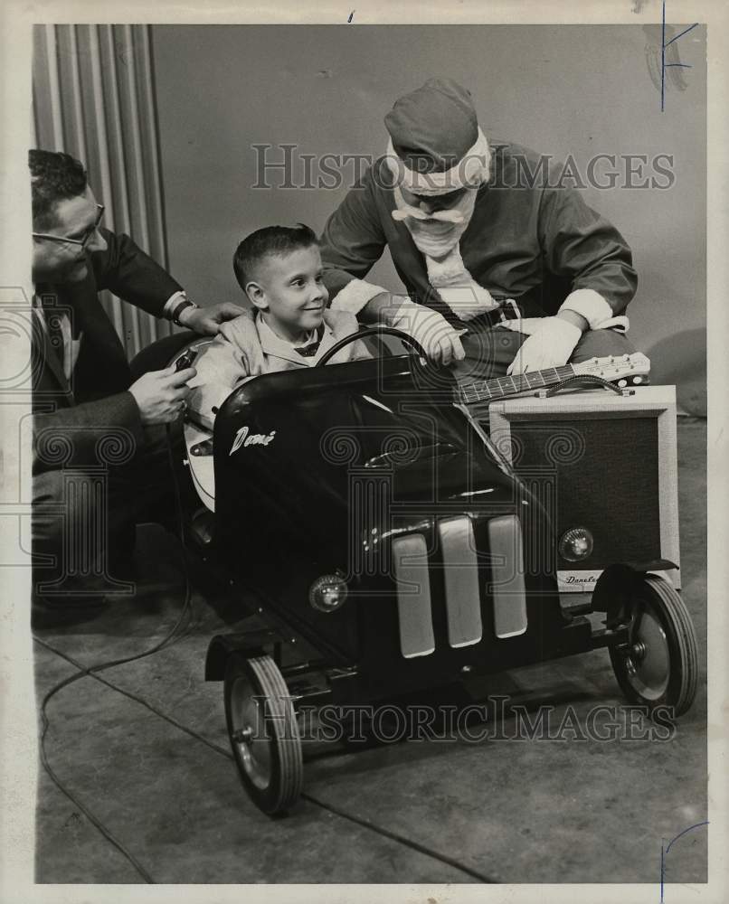 1960 Press Photo Santa helps ready Donnie Chandler for spin in toy car, Texas.- Historic Images