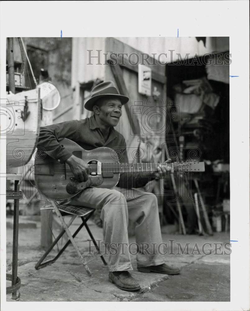 1960 Press Photo Singer Dennis Gainus of Crockett plays guitar on sidewalk- Historic Images