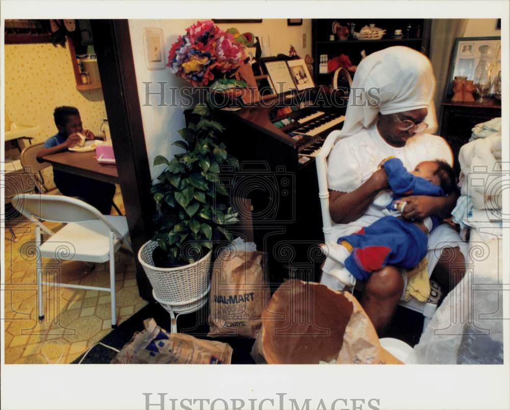 Press Photo Sister Helen Gay cares for baby as another child eats sandwich, TX- Historic Images