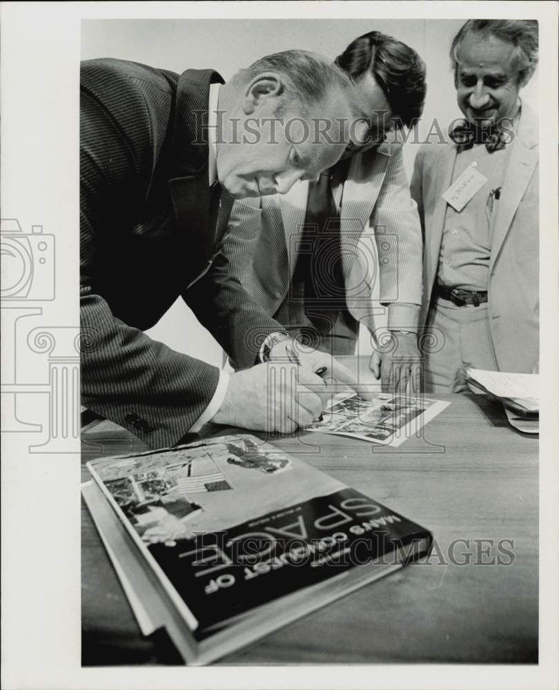 1973 Press Photo Cosmonaut Alexei Leonov signs pictures for reporters in Houston- Historic Images