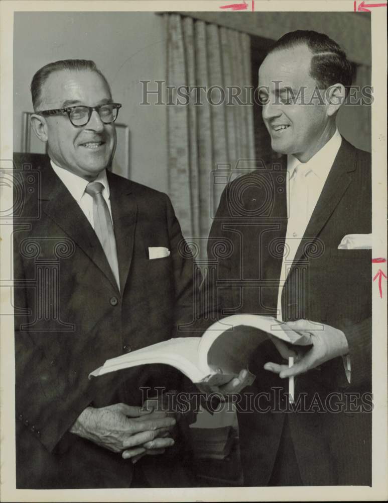 1963 Press Photo Lloyd Lunsford, attorney, and colleague looking at a book, TX- Historic Images