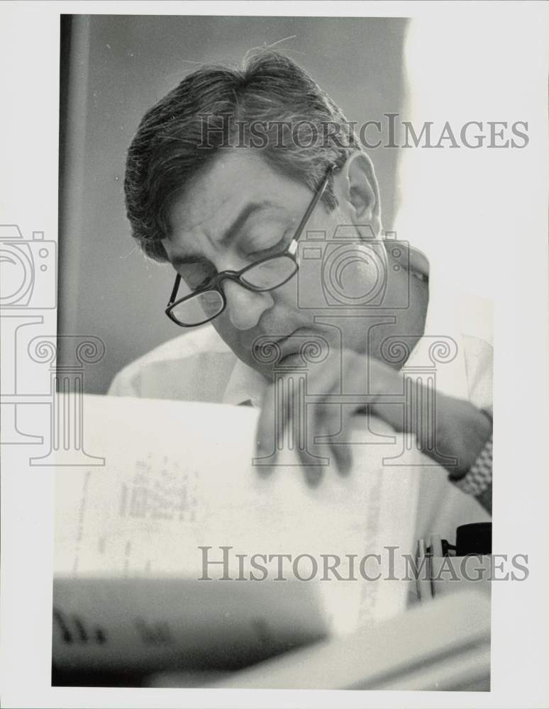 1985 Press Photo Louis Macey, MTA member looks through folder. - hpa77203- Historic Images