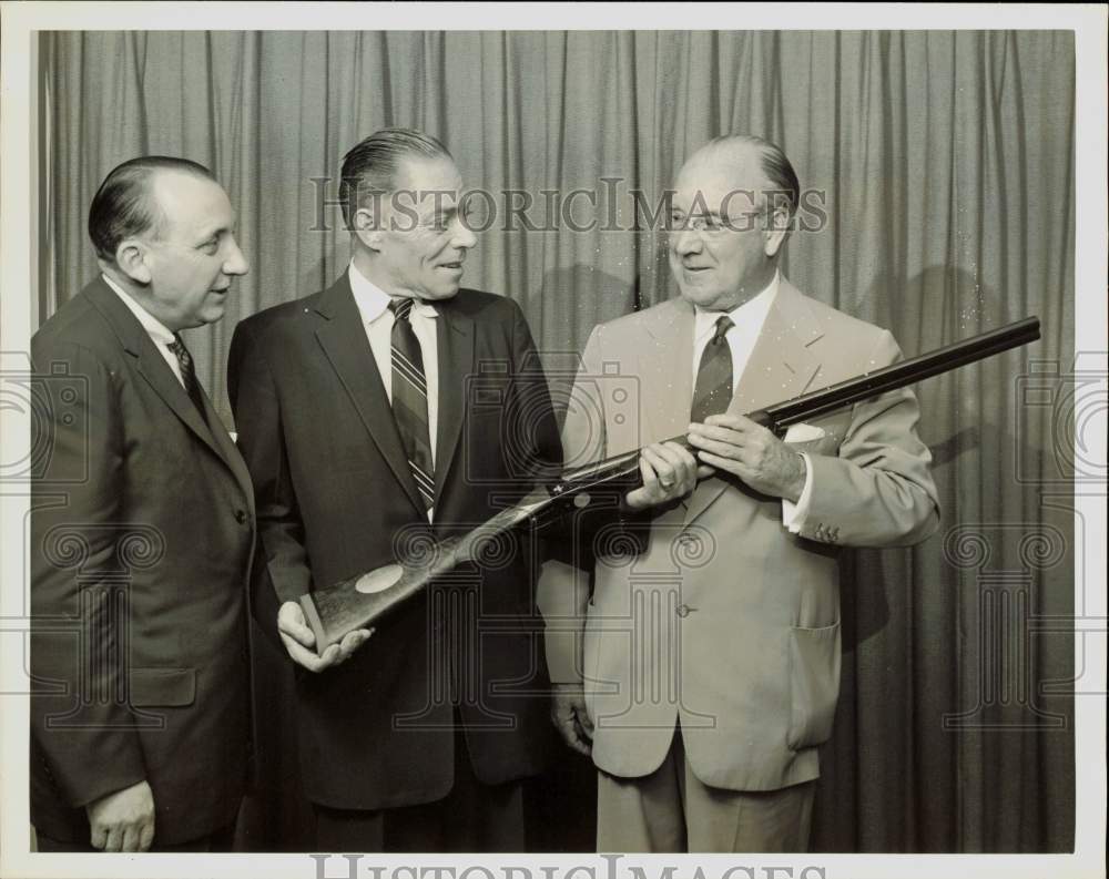 1957 Press Photo Dr. Logan Bennett presented Winchester shotgun by John Olin.- Historic Images