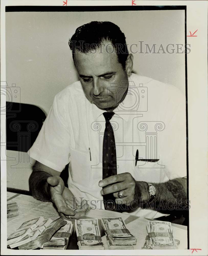 1969 Press Photo Pokey Sammons, robbery detective views seized cash. - hpa83323- Historic Images