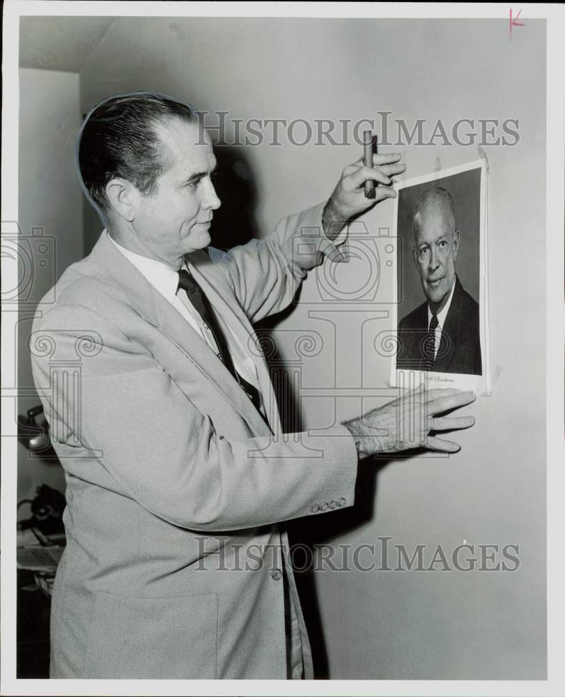 1956 Press Photo Weldon Douglas hangs portrait of Eisenhower in Texas.- Historic Images