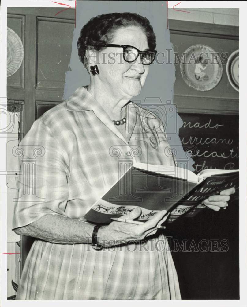 1962 Press Photo Mrs. Mary Makeig, retired teacher, reading book in classroom.- Historic Images