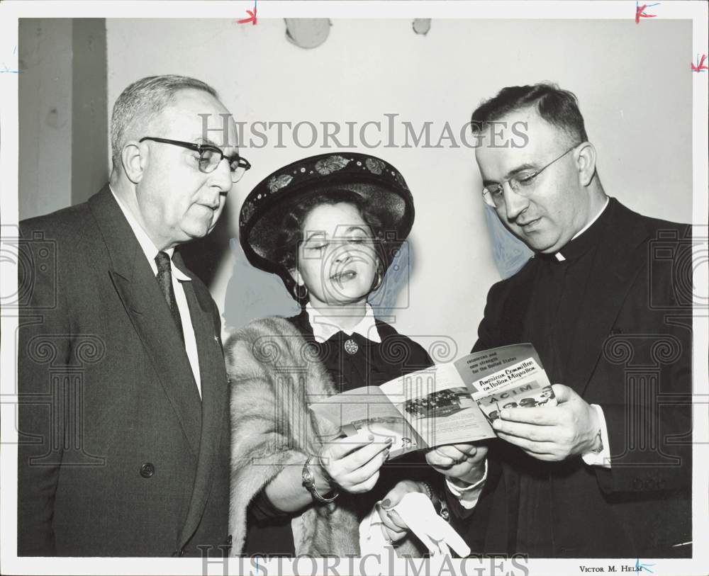 1957 Press Photo Mrs. Bruno Bagnoli and Reverend Donanzan view brochure.- Historic Images