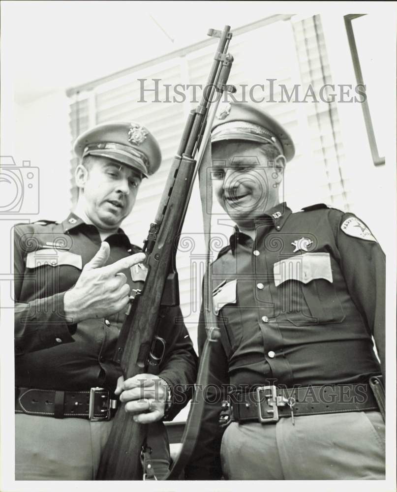 1963 Press Photo Harris County policemen H.D. Owen and T.M. Garbett view rifle.- Historic Images