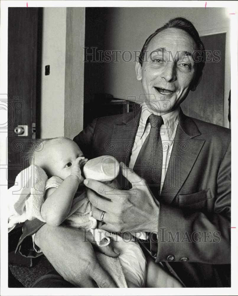 1974 Press Photo Detective W.H. Schroeder, Feeding Baby, in Houston - hpa87039- Historic Images