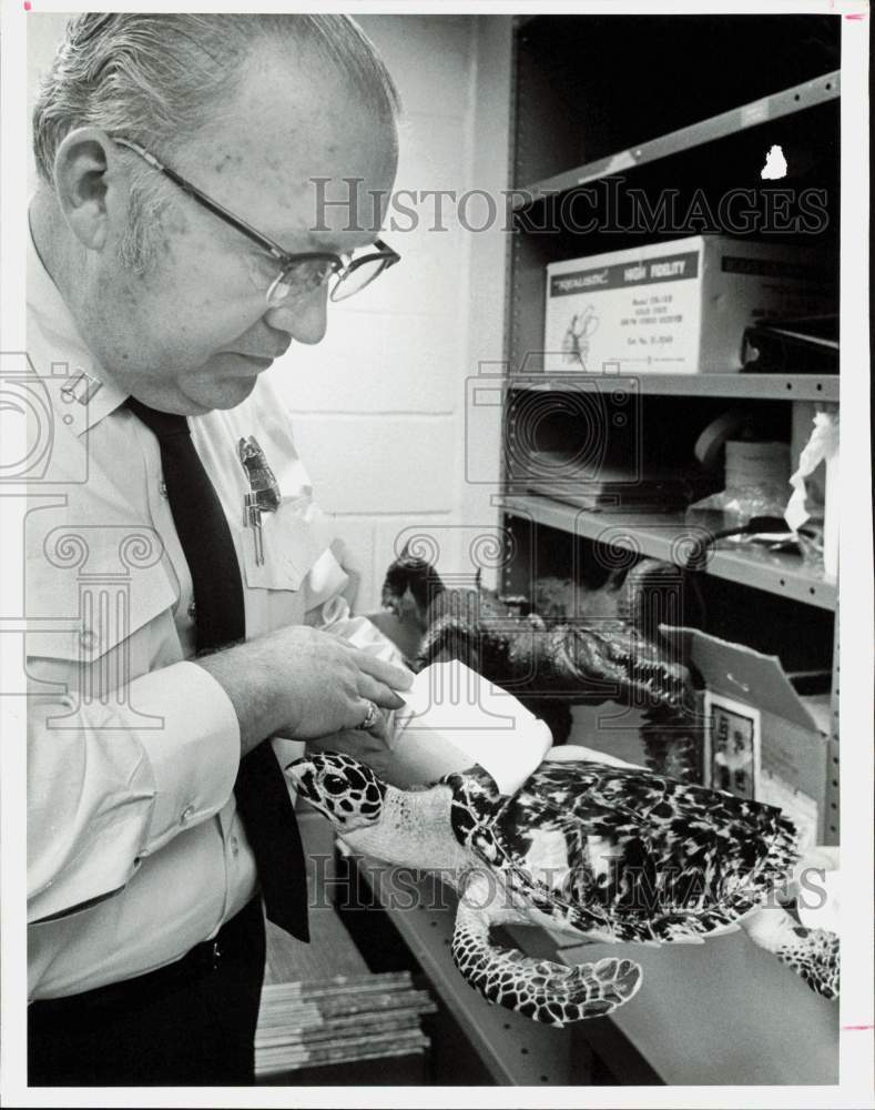 1975 Press Photo U.S. Customs Service Agent Ernie Atchley Checks Seized Items- Historic Images