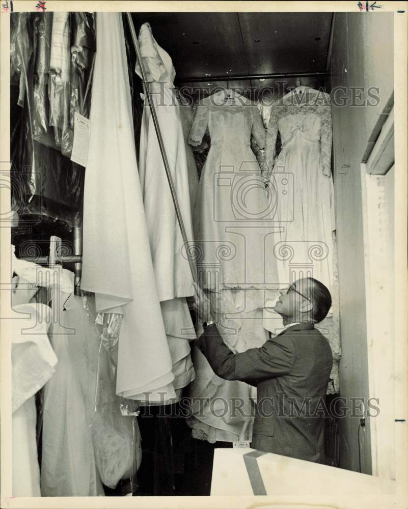 1966 Press Photo B.E. Langdon Hangs Wedding Dress in Cold Storage Vault- Historic Images