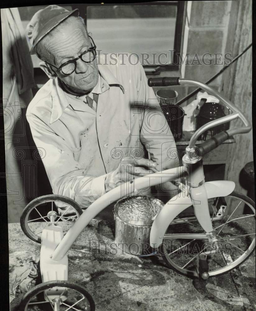 1958 Press Photo Salvation Army Worker Ben Knighton Paints Tricycle, Christmas- Historic Images