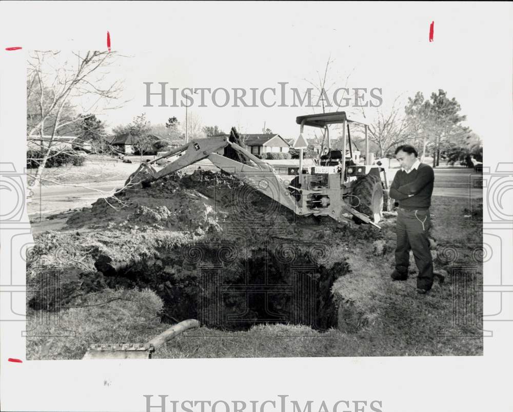 1984 Press Photo Antonio Torres looks at water main repair in his front yard.- Historic Images