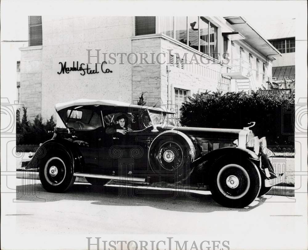 1956 Press Photo Young boy looks from ancient auto outside Marble Steel Company.- Historic Images