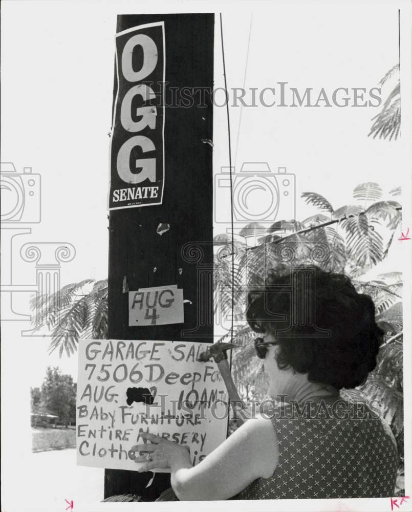 1972 Press Photo Woman nails yard sale sign on phone pole in Houston - hpa91438- Historic Images