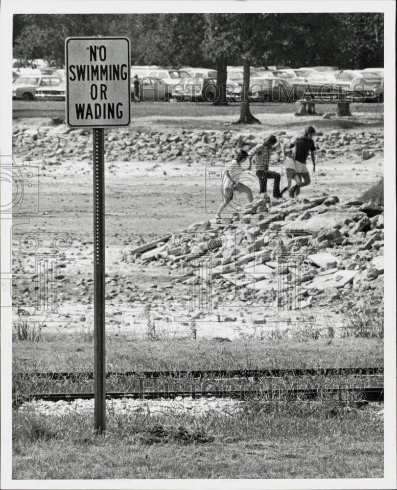 1974 Press Photo Young people hike in Hermann Park drained pond. - hpa91735- Historic Images