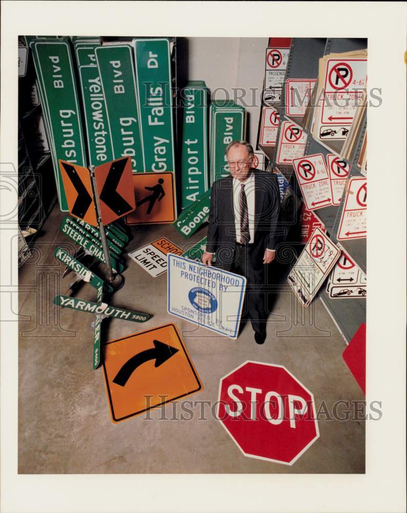 1989 Press Photo Harvey Hawkins surrounded by street and traffic signs.- Historic Images