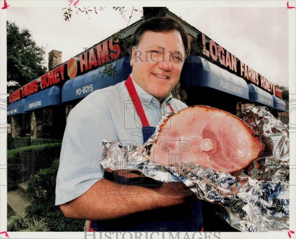 1994 Press Photo Pink Logan shows ham at Logan Farms Honey Glazed Ham store.- Historic Images