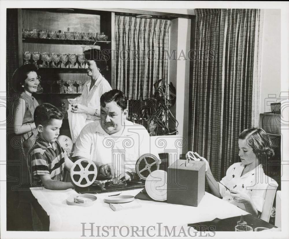 1957 Press Photo Ed Leach and family look through film rolls in Galveston.- Historic Images