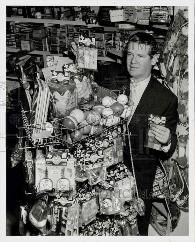 1956 Press Photo Lawrence Cooke of Texas Toy Company loads toys on racks.- Historic Images