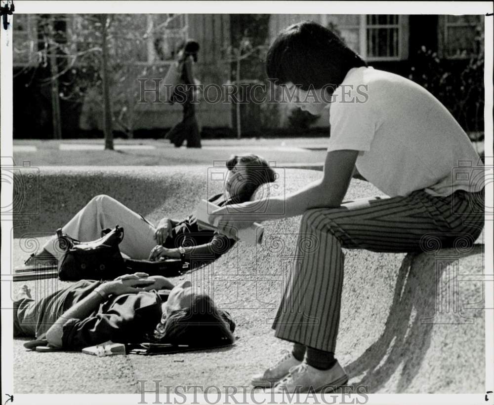 1975 Press Photo University of Houston students relax at campus reflection pool.- Historic Images