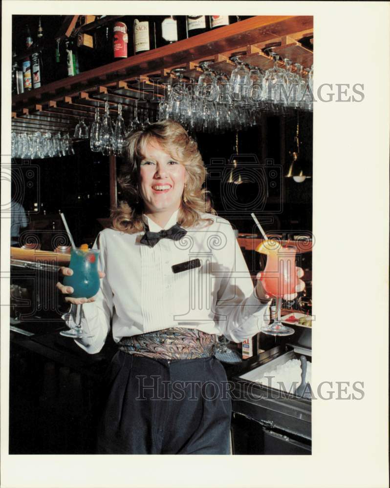 1988 Press Photo Quincy&#39;s Bartender Shirley Honcoop holds alcoholic drinks.- Historic Images