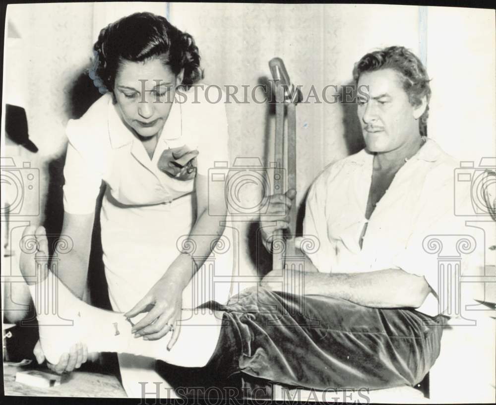 1956 Press Photo Hedda Hopper Checks on Actor Errol Flynn&#39;s Broken Ankle- Historic Images