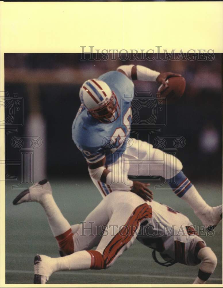 1987 Press Photo Oilers&#39; Mike Rozier leaps over Lewis Billups. - hps01568- Historic Images