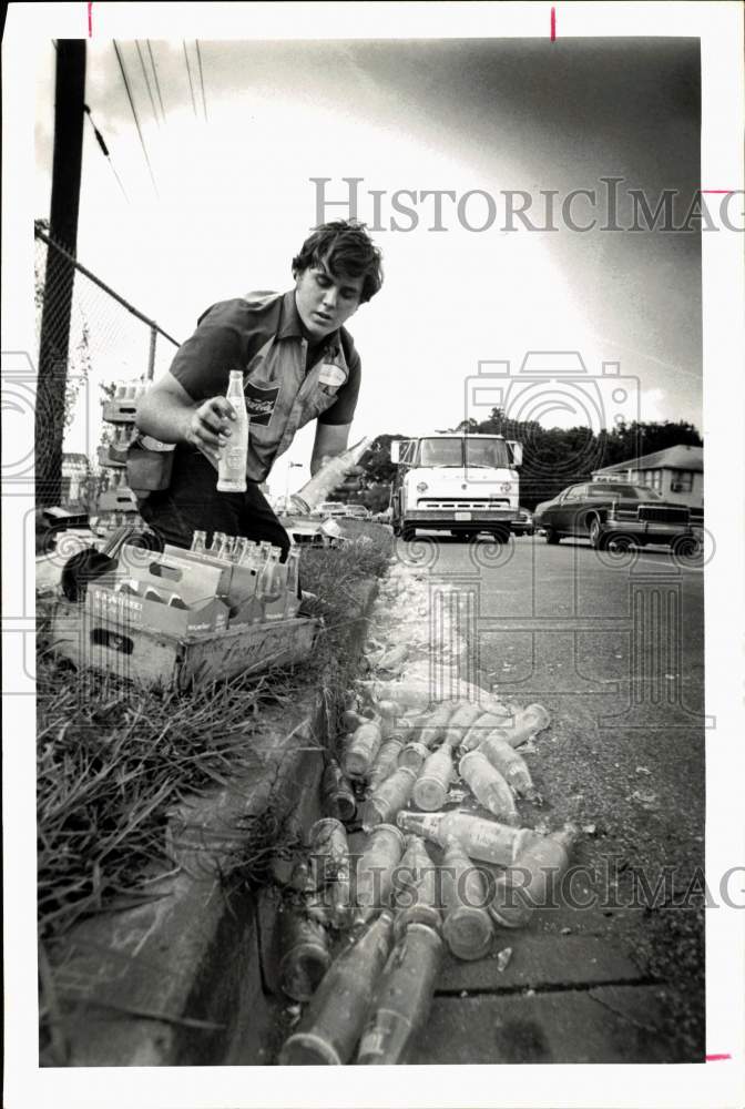 1975 Press Photo Matthew Wood cleans up empty bottles that feel off truck.- Historic Images