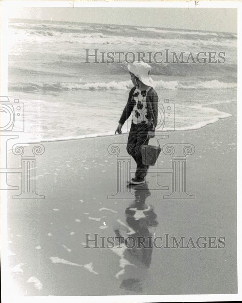 1973 Press Photo Youngster carries sand pail as he walks a Texas beach.- Historic Images