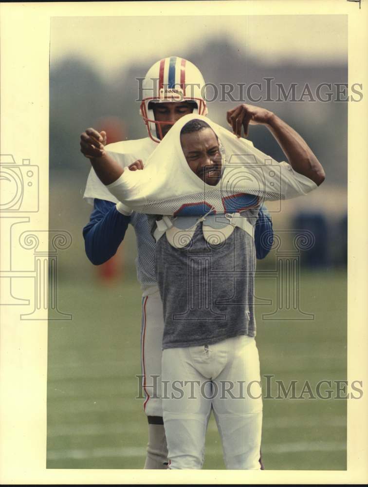 1989 Press Photo Teammate Helps Houston Oiler Drew Hill with Put On Jersey- Historic Images