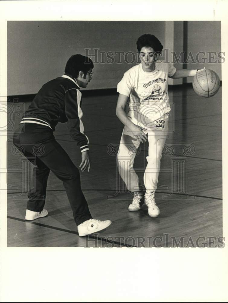 1986 Press Photo Basketball coach Pete Martinez plays with Melanee Kaplan- Historic Images