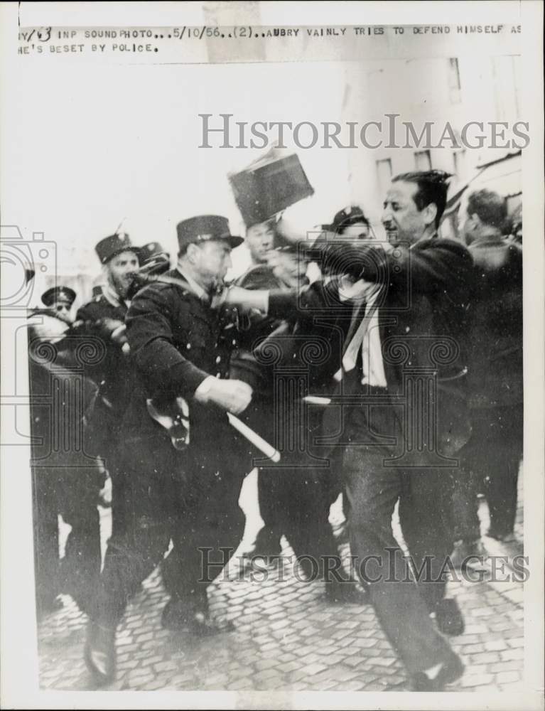 1956 Press Photo Photographer Aubry tries to defend himself from police.- Historic Images