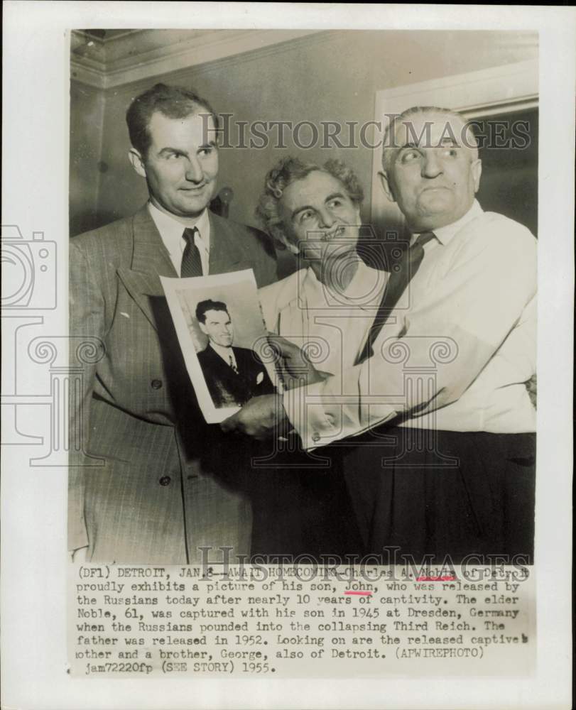 1955 Press Photo Charles Noble and family view John Noble&#39;s photo in Detroit.- Historic Images