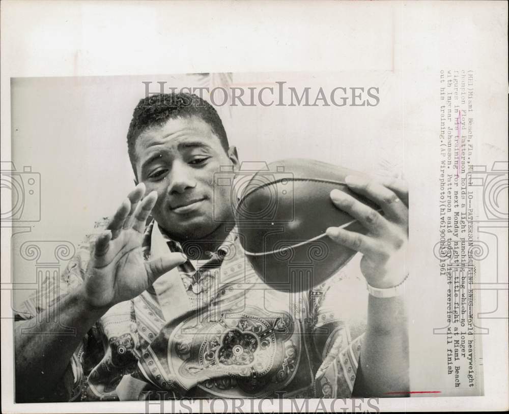 1961 Press Photo Boxer Floyd Patterson holds punching bag in Miami Beach, FL- Historic Images