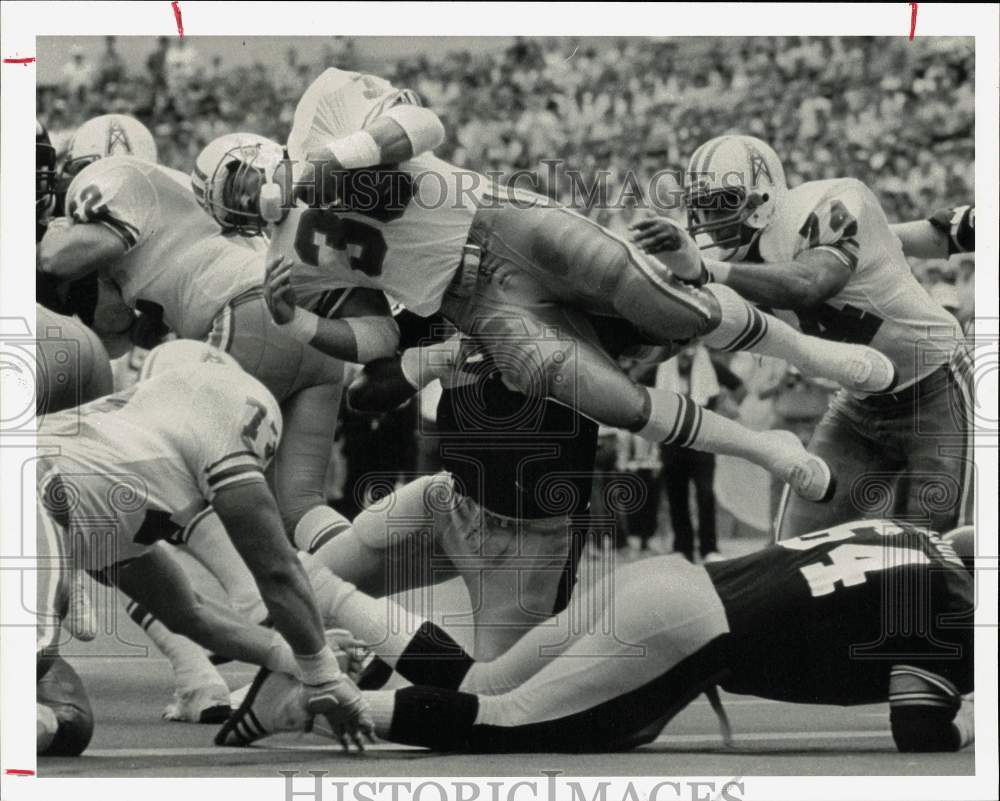 1985 Press Photo Oilers&#39; Larry Moriarty dives over Steelers for extra yardage- Historic Images