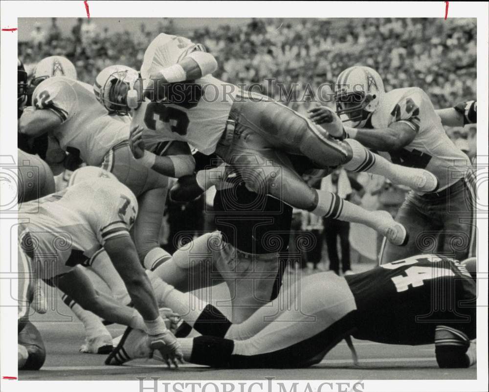 1985 Press Photo Oilers' Larry Moriarty dives over Steelers for extra yardage- Historic Images
