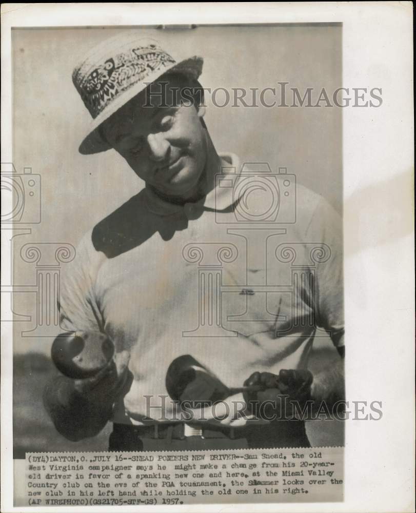 1957 Press Photo Sam Snead looks at his new and old golf clubs in Dayton, Ohio- Historic Images