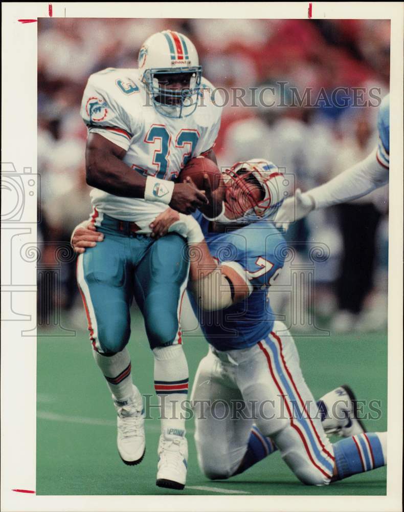 1989 Press Photo Oilers&#39; Ray Childress brings Miami footballer Sammie Smith down- Historic Images