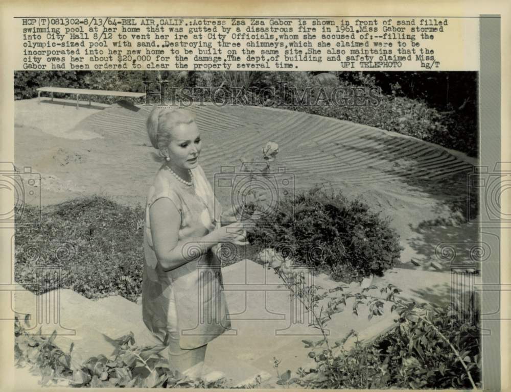 1964 Press Photo Zsa Zsa Gabor stands near sand filled pool at her Bel Air home- Historic Images