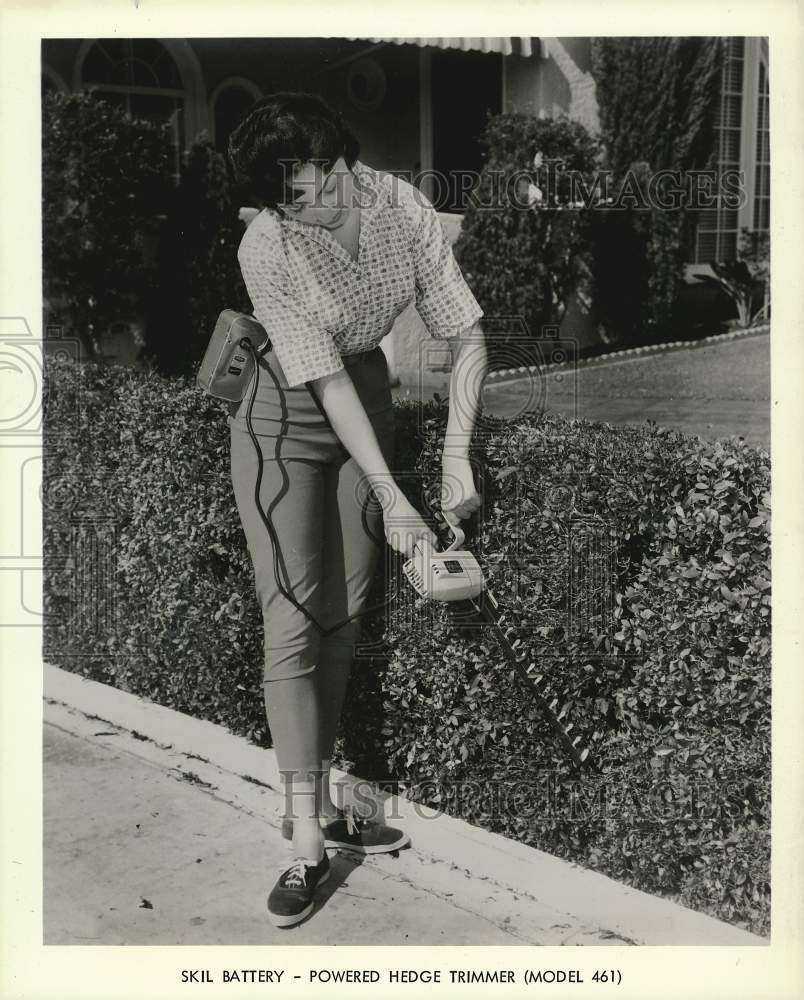 Press Photo Model demonstrates the Skil-Powered Hedge Trimmer, Model 461.- Historic Images